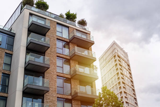 Contemporary Urban Apartments with Rooftop Greenery Modern apartments with spacious balconies and rooftop gardens under a cloudy sky, emphasizing green living. santana photos stock pictures, royalty-free photos & images