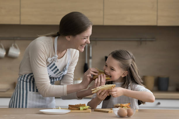 istock Mother feeds her cute daughter with fresh prepared sandwich 2148851148