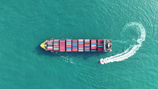 Cargo Container ship running with pilot boat in the ocean. sea port. container ship import export to customers sea port. export shipping industry freight and transportation logistics concept.