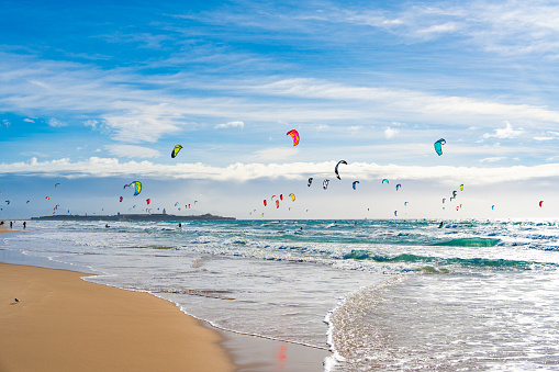Tarifa beach in Cadiz surf city skyline of Andalusia Spain with lots of kitesurfing kites under blue sunny sky