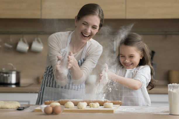 istock Mother and little daughter having fun while cooking in kitchen 2148852587