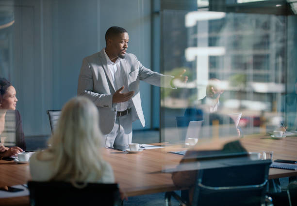 istock Meeting, business man and presentation in conference room for discussion, planning or problem solving. Professional, office and male employee with staff for corporate idea, vision or collaboration 2148852696