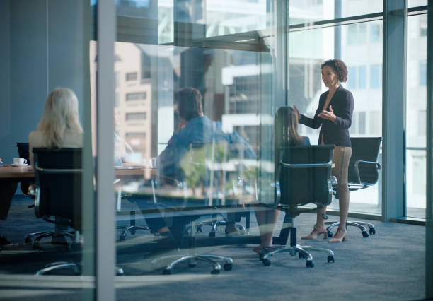 istock Business people, talking at meeting or presentation for corporate training, briefing or planning in office. Company speaker and employees, listening at seminar for vision or innovation in boardroom 2148852709