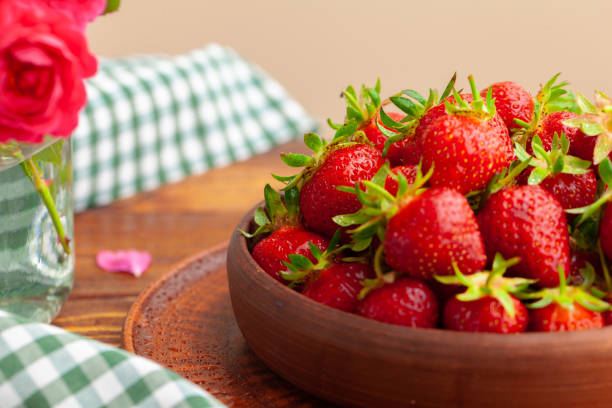 istock Heap of fresh strawberries in ceramic bowl on rustic background 2148852899