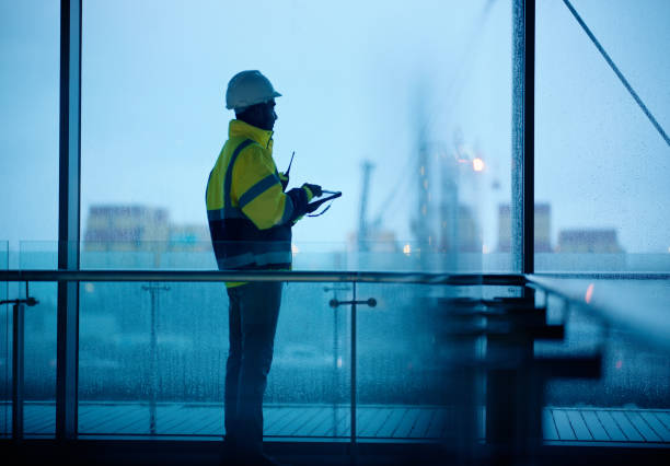 istock Construction, building and man with tablet at night for inspection, planning and maintenance. Civil engineering, thinking and person in ppe on digital tech for project, infrastructure or architecture 2148855687