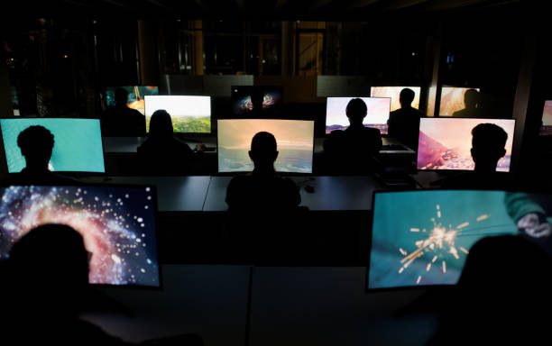 istock People, night and computer screen in centre, cyber security or information observation on technology pc. Collaborative, workspace or team in office, back view and colleagues working together 2148855963