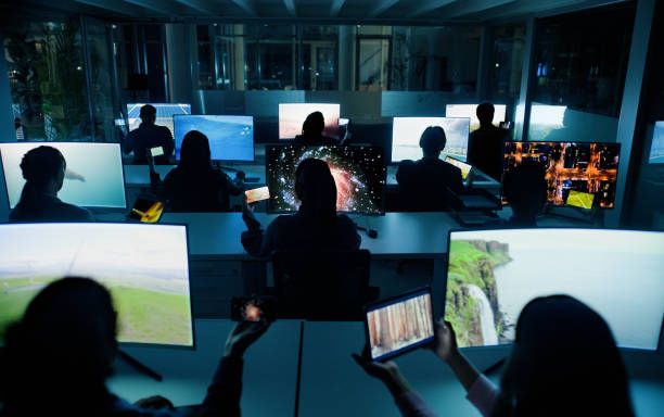 istock People, night and computer screens in centre, streaming or videographer or content creation on technology pc. Collaborative, social media or team in office, back view or colleagues working together 2148856009