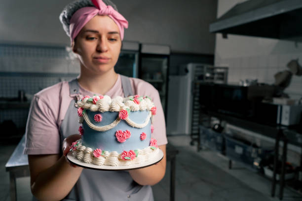 istock in a professional kitchen a female baker stands with a finished cake in her hands 2148856143