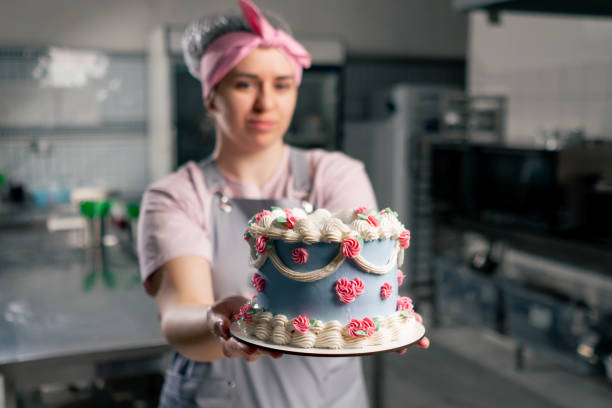 istock in a professional kitchen a female baker stands with a finished cake in her hands 2148856230