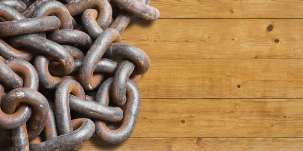 Tangled old rusty metal chain on wooden background - concept with copy space