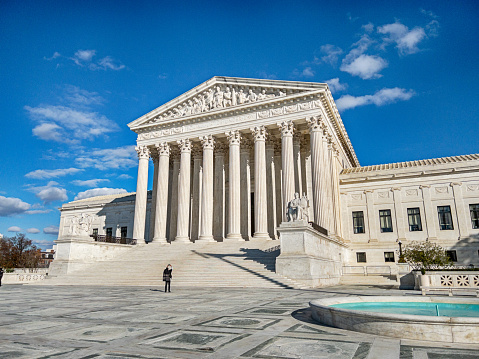 Washington DC, November 16, 2022: On a cold day in winter, one anonymous person stands in front of the Supreme Court of the United States.