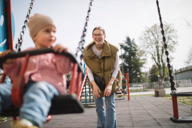 istock Mother pushing daughter on swing 2148859803