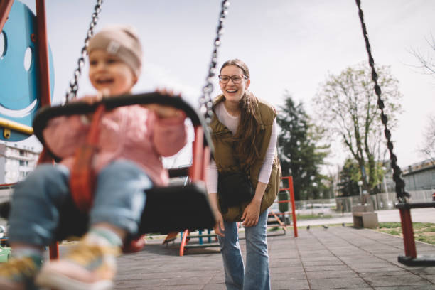 Mother pushing daughter on the swing