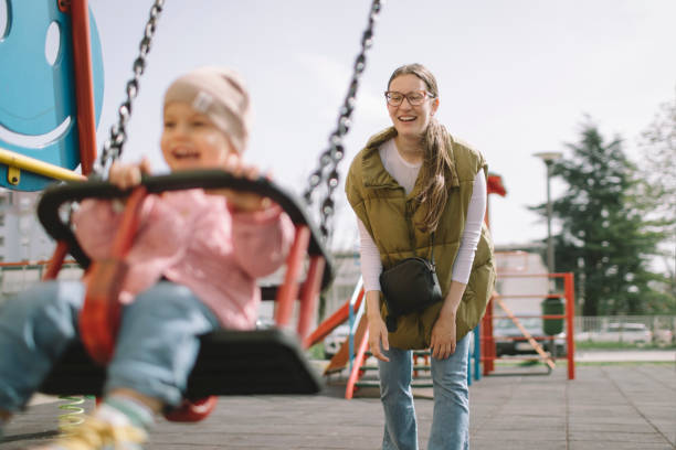 istock Mother pushing daughter on the swing 2148859820