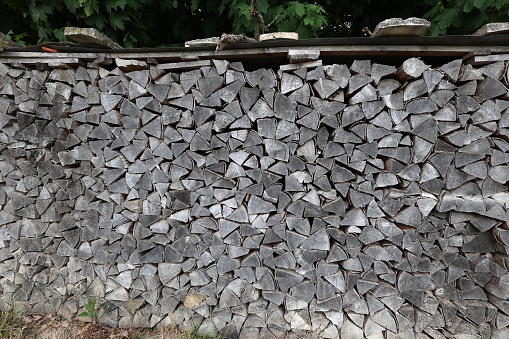 Dry firewood is evenly stacked in the woodpile.