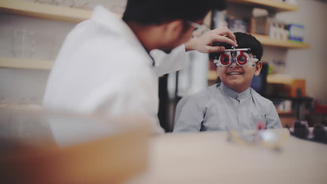 Indian boy is measured eyesight in optical shop