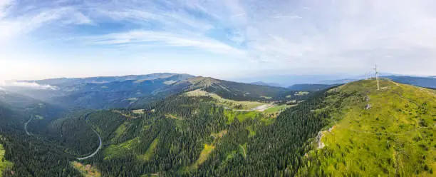 Panoramic view of the Weinebene and Koralpe mountain range in Styria. Wind energy park at the Handalm mountain pasture.