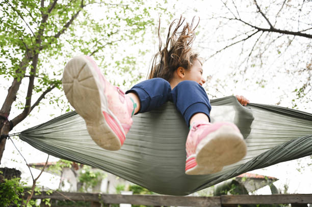 Cute laughing girl swinging in a hammock.