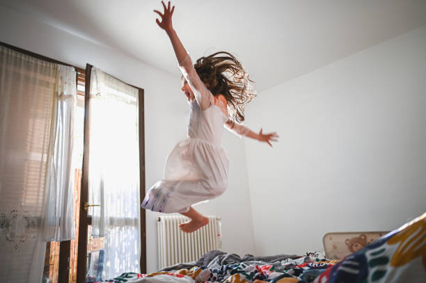 istock Freedom and happiness. Child jumping on a bed. 2148864395