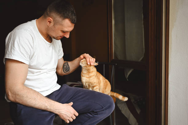 istock Millennial man cuddling cat at home. 2148864442