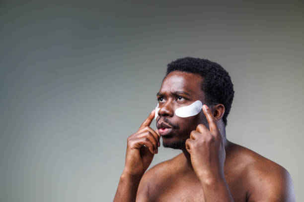 istock Young man using skin care product - studio shot 2148865301