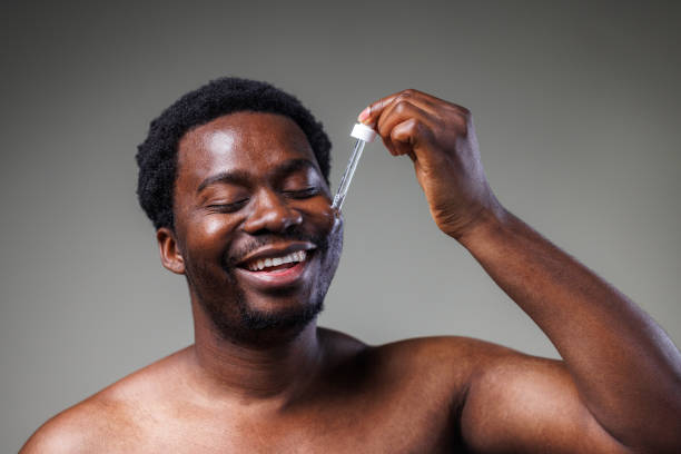 istock Young man using a beauty product - face serum 2148865354