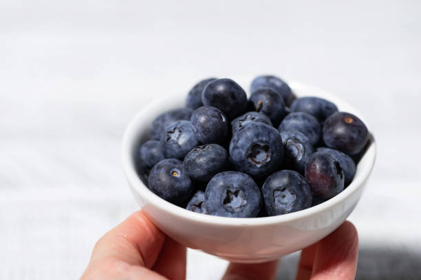 istock fresh blueberries in a white bowl in hand 2148866134