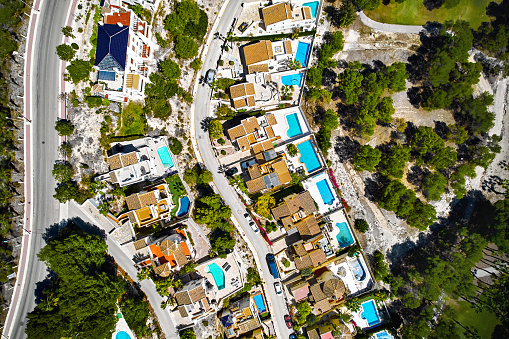 Drone point of view of luxury villas with swimming pools during sunny summer day. Real-estate, new build property and development concept. Spain, Costa Blanca. Alicante Province