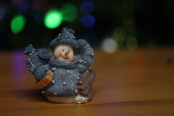 Snowman toy on table on christmas background.
