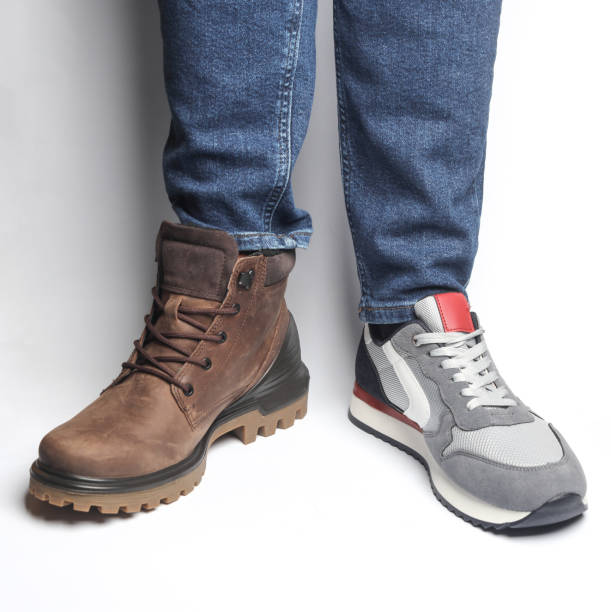 Male legs in different shoes on a white background