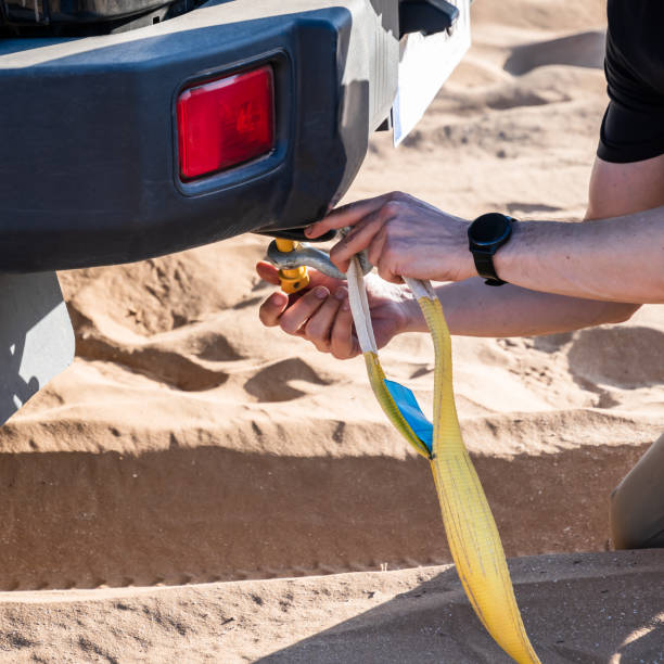 Panorama smashed bumper front fender on pickup truck by car accident on flatbed rollback tilt tray of tow truck with yellow ratchet strap tie down, collision, insurance claim concept, Texas. USA