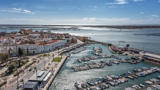 Traditional Portuguese oceanfront city of Faro with old architecture, filmed by drone. Arco de villa and largo de se. Ria formosa in the background. High quality 4k footage