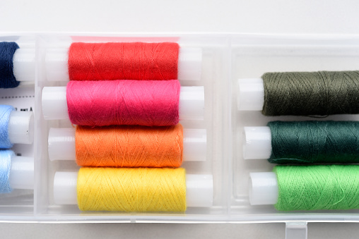 Multicolored skeins of thread in the set. The threads are in a plastic box.