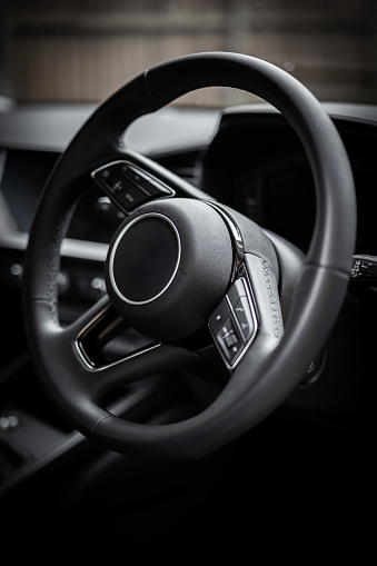 black car steering wheel close-up. Modern design. Car interior. Travel.