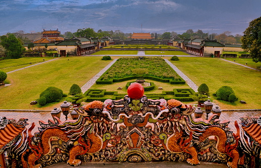 A dragon ceramic mosaic and view of the gardens from the Palace of Supreme Harmony -Thai Hoa Palace- in the Citadel of Hue Imperial City, Vietnam