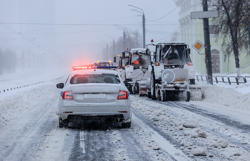 Clearing snow from city streets using special equipment under police supervision