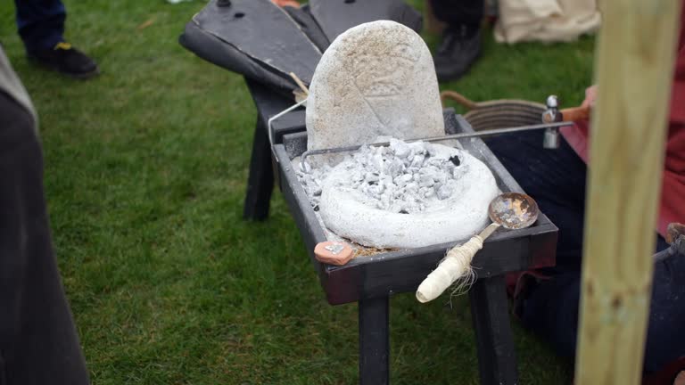 Portable forge with hot coals and tools, used for live demonstrations in metalworking and historical reenactments. Essential for educational footage about traditional blacksmithing techniques