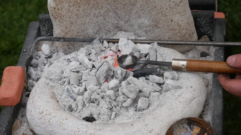 Detailed view of a blacksmith's forge with fiery coals melting metals and tongs, depicting the art of metalworking. Ideal for cultural heritage, craftsmanship, and educational.