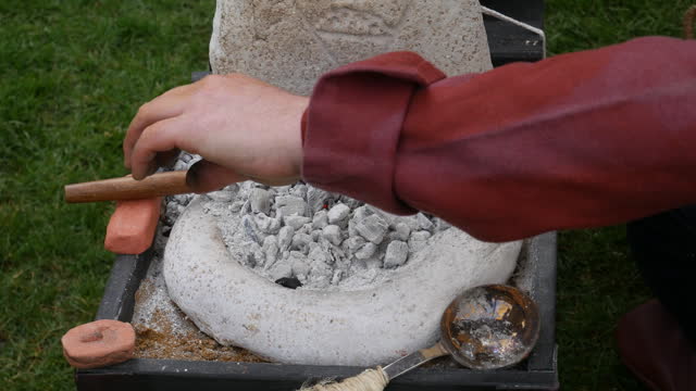 Close-up of a small forge with glowing embers, blacksmith tools, and anvil, showcasing traditional metalwork. Suitable for documentaries and educational content on crafting and smithing