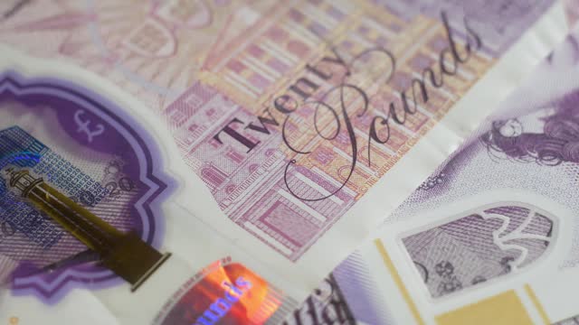 360 degree rotating showcase macro shot of Banknotes english pounds front sides footage. Elements of bill close up