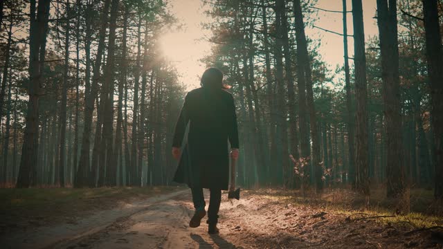 Mysterious Figure Holding Axe Walking in Forest at Twilight