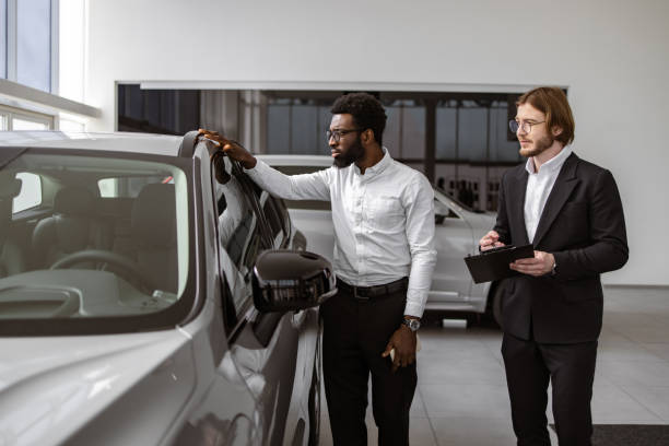 istock Consultant provides all information about new car using clipboard to male client 2148876424