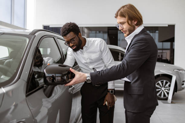 istock Consultant provides all information about new car using clipboard to male client 2148876433