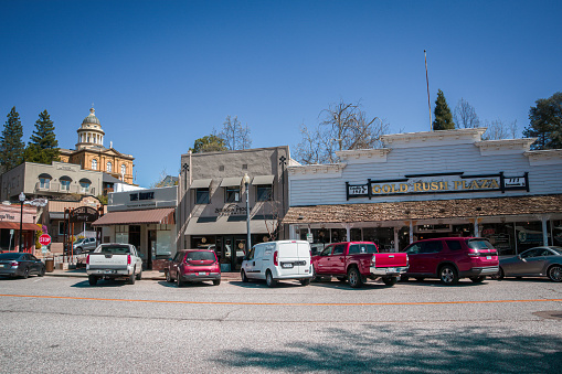 Auburn, CA, U.S.A. - March 25, 2024: Photo of the historic Gold Rush Plaza and other retail shops in the historic old town, with the historic courthouse in the background.