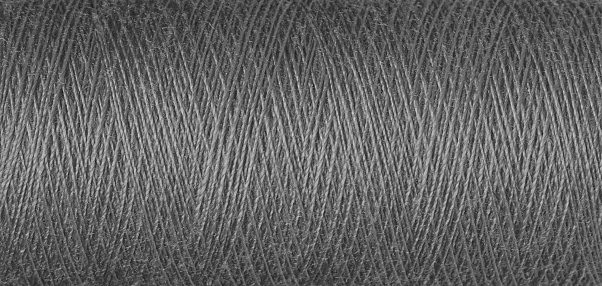 macro texture of a skein of grey sewing thread close-up