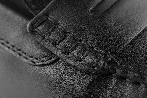 texture of black leather with thread stitching close-up