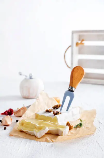 Photo of camambert cheese with nuts on white table