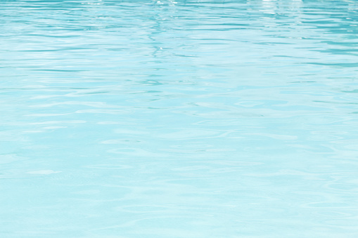 Swimming pool surface. Abstract background with water texture in waves.