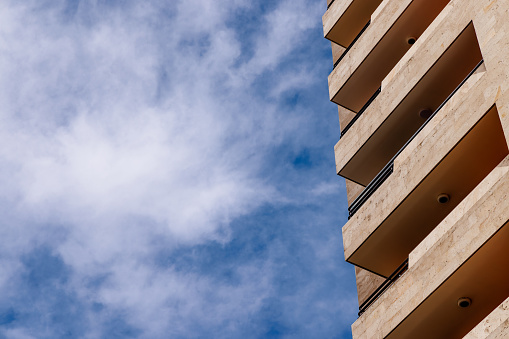 Geometric perfection. A part of modern apartment building against partly cloudy sky