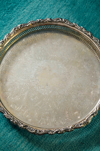 large round silver serving tray on teal rug